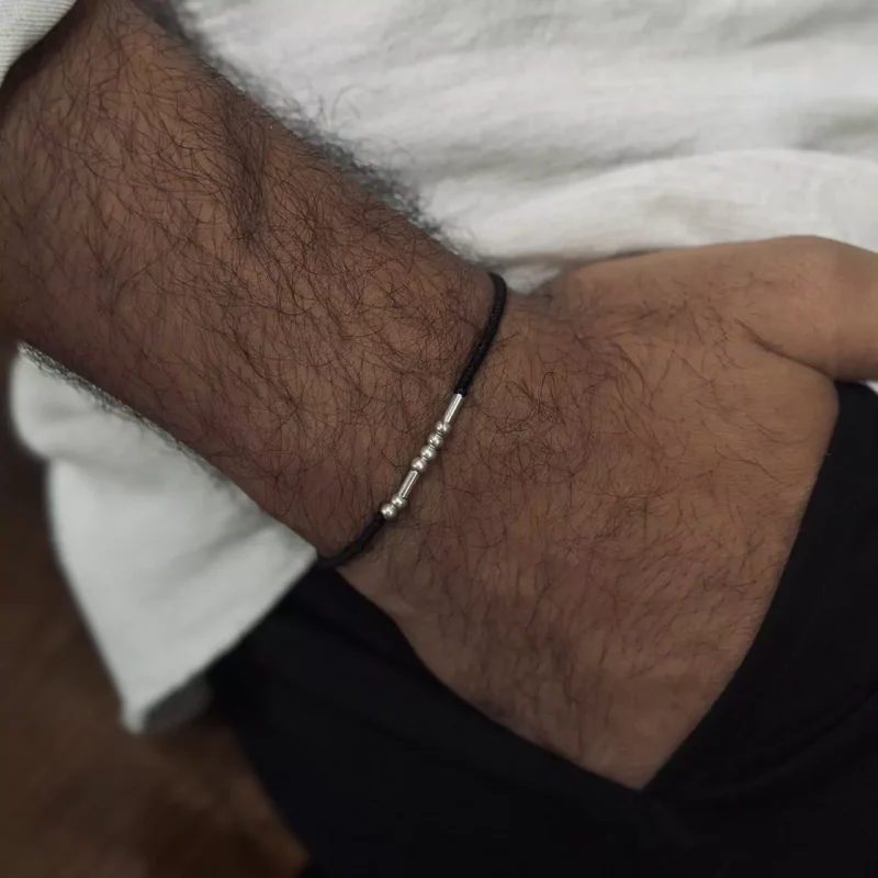 دستبند نقره‌ای مورس روی دست مردانه با استایل غیررسمی
